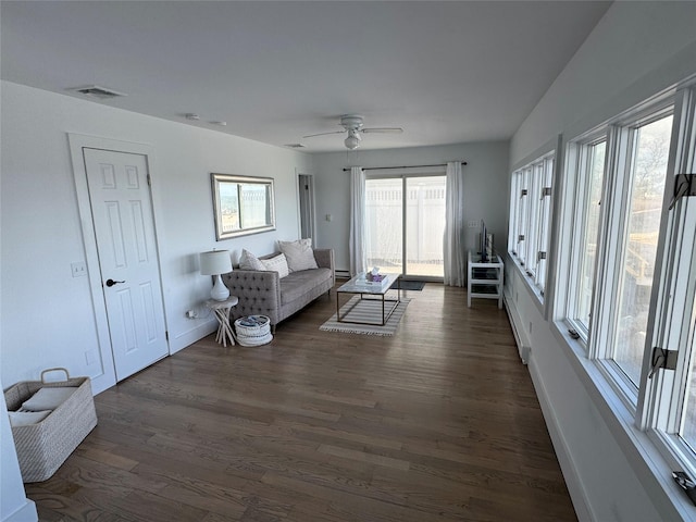 living room with ceiling fan, plenty of natural light, a baseboard radiator, and dark hardwood / wood-style flooring