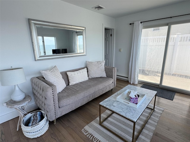 living room with wood-type flooring and a baseboard heating unit