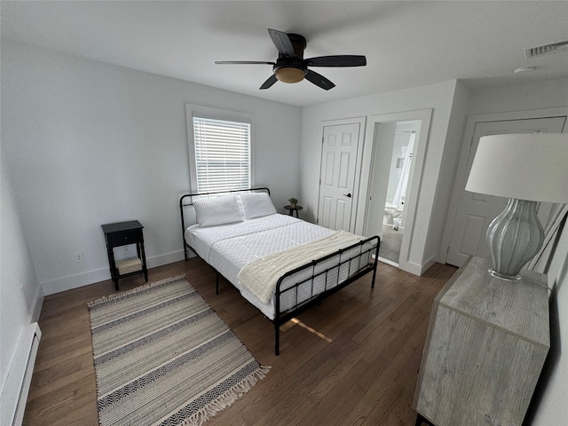 bedroom featuring ceiling fan, baseboard heating, dark hardwood / wood-style flooring, and connected bathroom