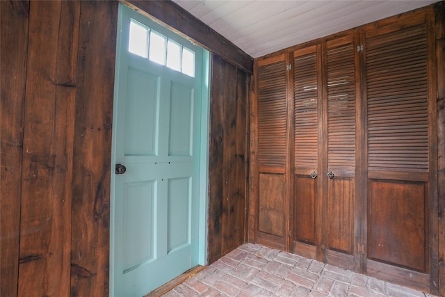 foyer entrance featuring wood walls