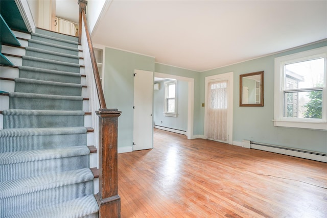 entryway featuring crown molding, a baseboard radiator, and wood-type flooring