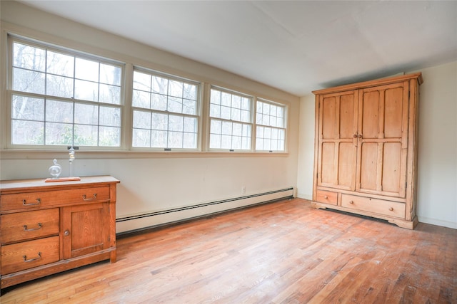 unfurnished bedroom with baseboard heating and light hardwood / wood-style flooring