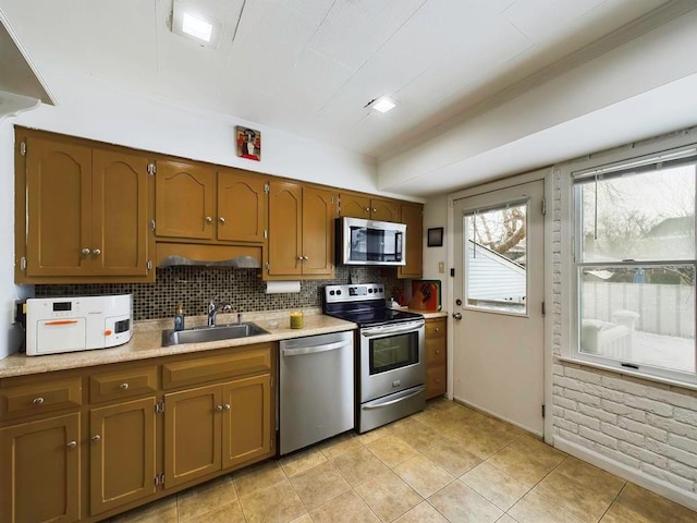 kitchen with tasteful backsplash, sink, light tile patterned floors, and stainless steel appliances