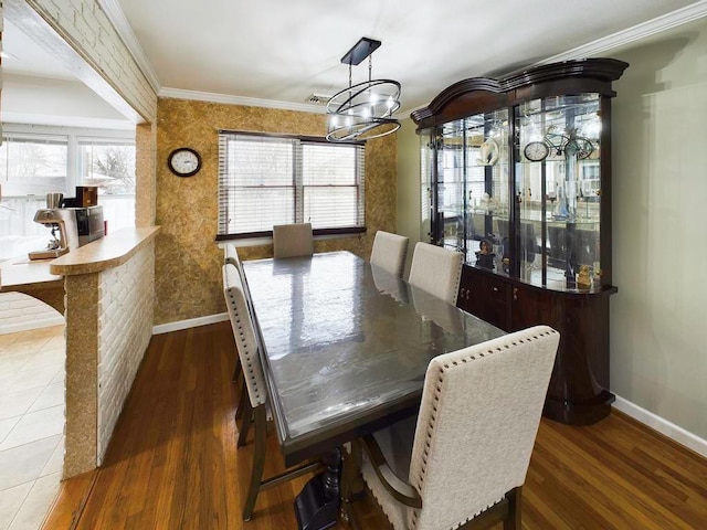 dining space featuring dark hardwood / wood-style flooring, crown molding, and a notable chandelier