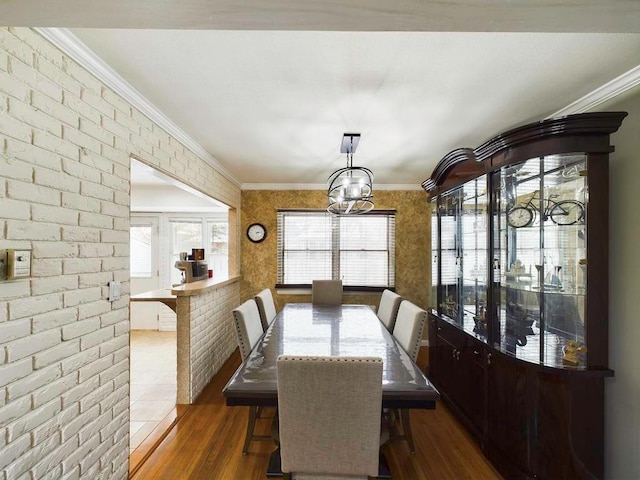 dining room featuring dark hardwood / wood-style floors, ornamental molding, and brick wall