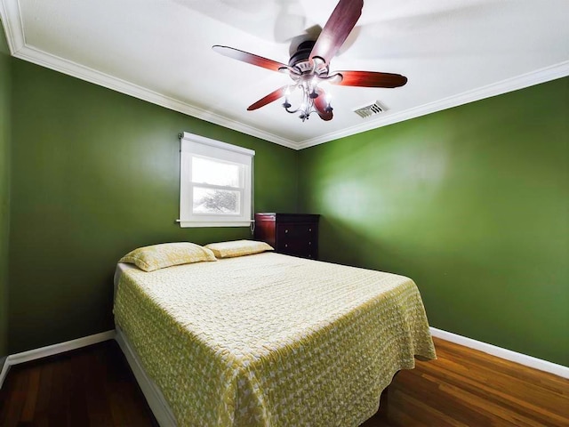 bedroom with ceiling fan, crown molding, and dark wood-type flooring