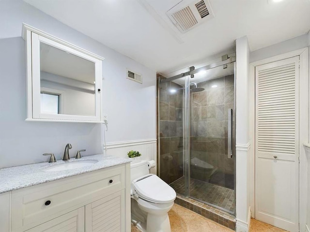 bathroom featuring tile patterned floors, a shower with door, vanity, and toilet