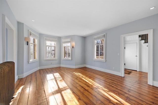 unfurnished room with a healthy amount of sunlight and light hardwood / wood-style floors