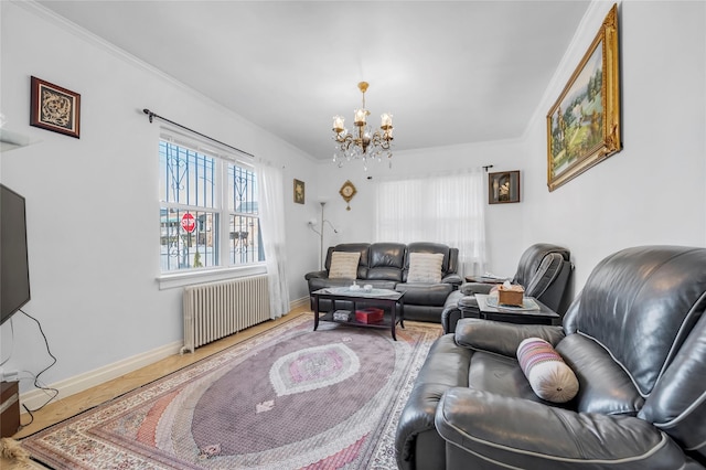 living room featuring radiator, hardwood / wood-style floors, ornamental molding, and a notable chandelier