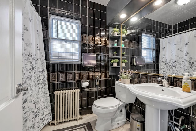 bathroom featuring radiator heating unit, tile walls, and toilet