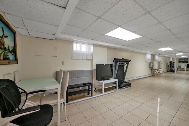 interior space with light tile patterned floors, a paneled ceiling, and baseboard heating