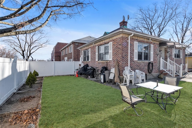 rear view of property with a patio and a lawn