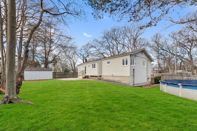 exterior space featuring a shed, a yard, and a covered pool