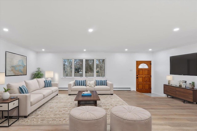 living room featuring baseboard heating, crown molding, and light hardwood / wood-style floors