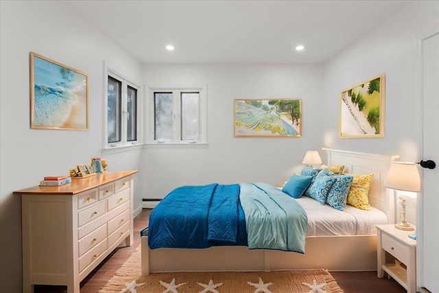 bedroom with hardwood / wood-style flooring and baseboard heating