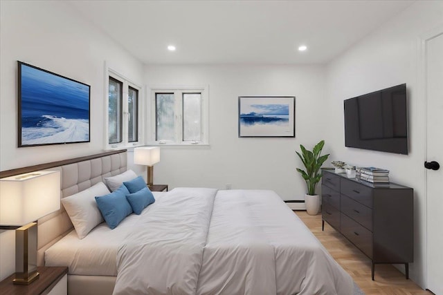 bedroom with light parquet flooring and a baseboard radiator