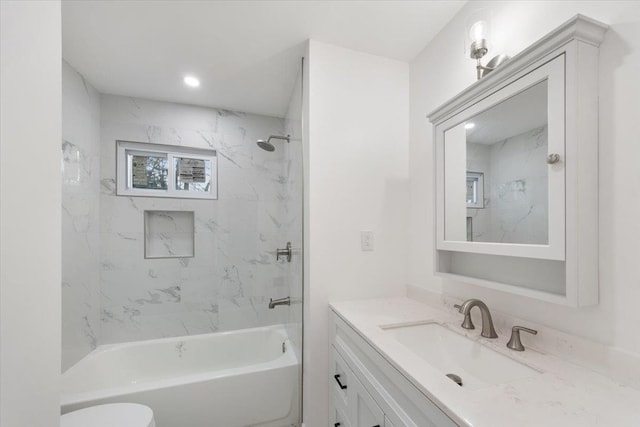 full bathroom featuring toilet, vanity, and tiled shower / bath