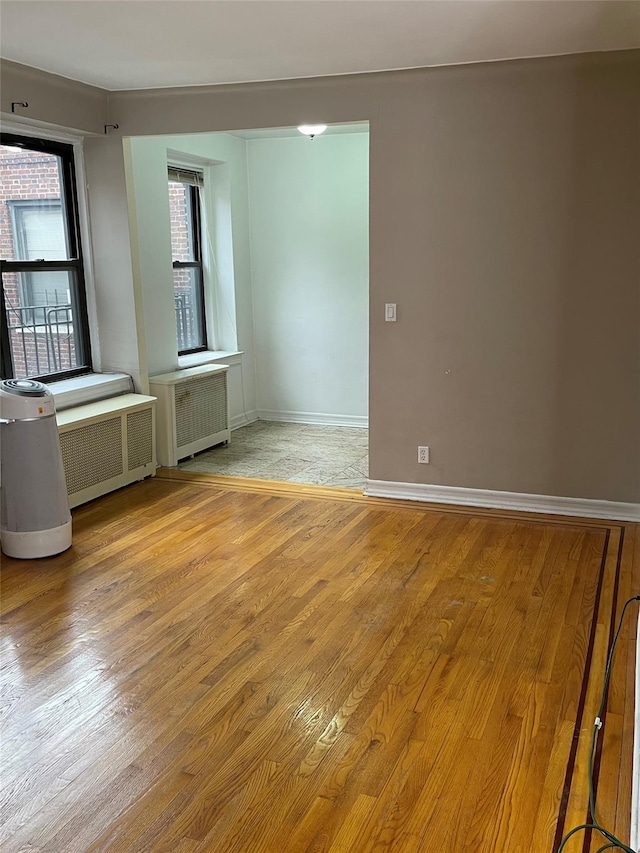 unfurnished room with light hardwood / wood-style floors and radiator