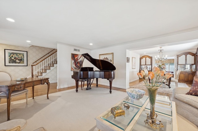 living room with a notable chandelier, light hardwood / wood-style floors, and ornamental molding