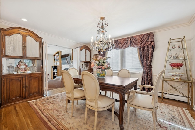 dining room with a notable chandelier, a baseboard heating unit, crown molding, and light hardwood / wood-style flooring