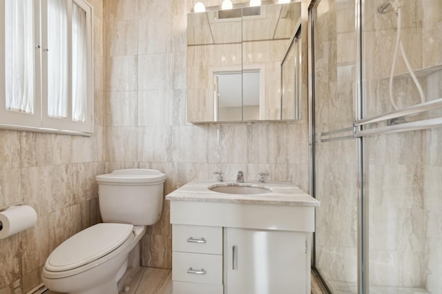 bathroom with vanity, tile walls, and toilet