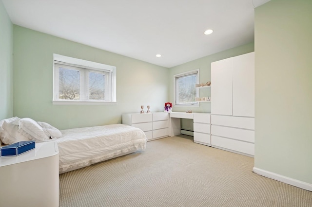 bedroom with light colored carpet and a baseboard radiator