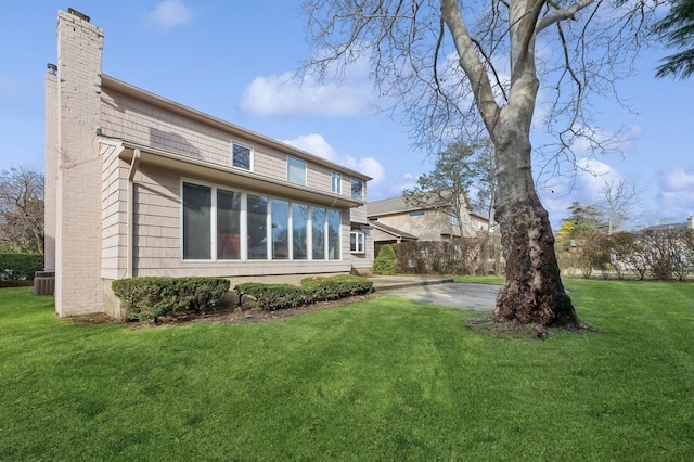 back of property featuring a yard and central AC unit