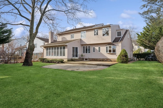 rear view of house with a yard and a patio