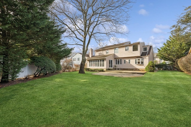 rear view of property with a lawn and a patio