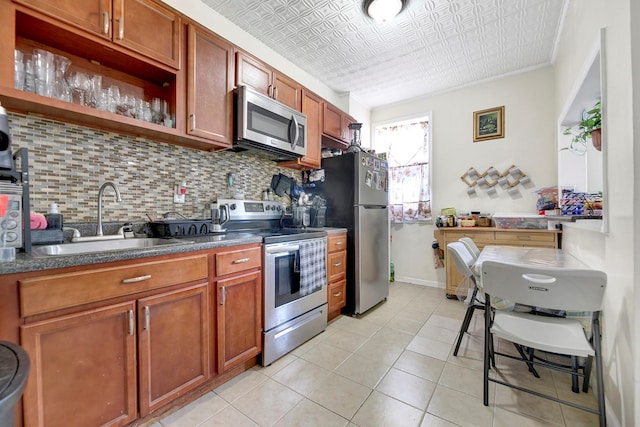 kitchen featuring sink, stainless steel appliances, crown molding, decorative backsplash, and light tile patterned flooring