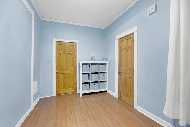 spare room with hardwood / wood-style floors and crown molding