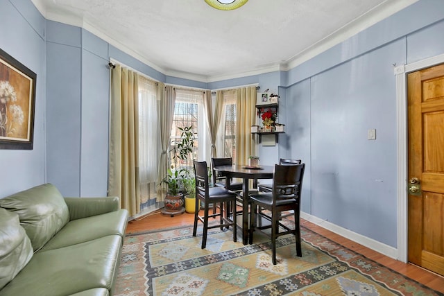 dining area featuring hardwood / wood-style floors and crown molding