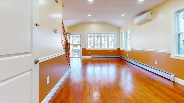 empty room with a healthy amount of sunlight, vaulted ceiling, a wall mounted AC, and a baseboard heating unit