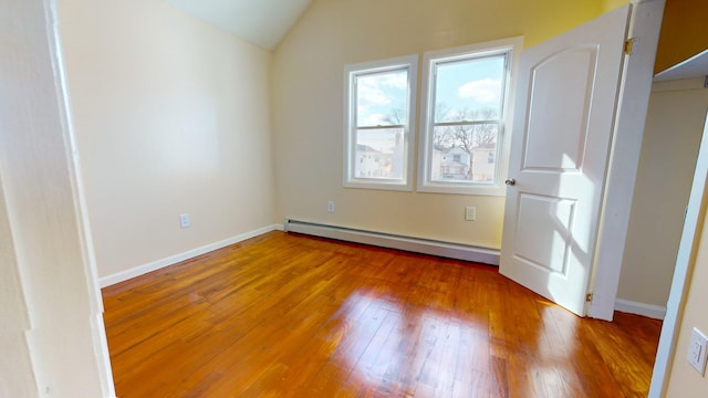 interior space featuring baseboard heating, wood-type flooring, and lofted ceiling