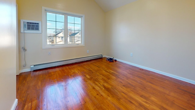 empty room featuring hardwood / wood-style floors, lofted ceiling, a wall unit AC, and a baseboard radiator