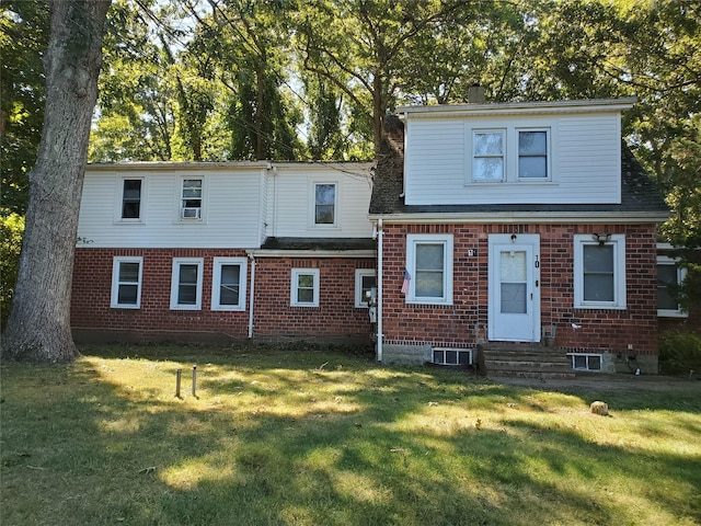 rear view of property featuring a lawn and central air condition unit