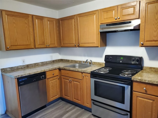 kitchen with appliances with stainless steel finishes, dark hardwood / wood-style floors, and sink