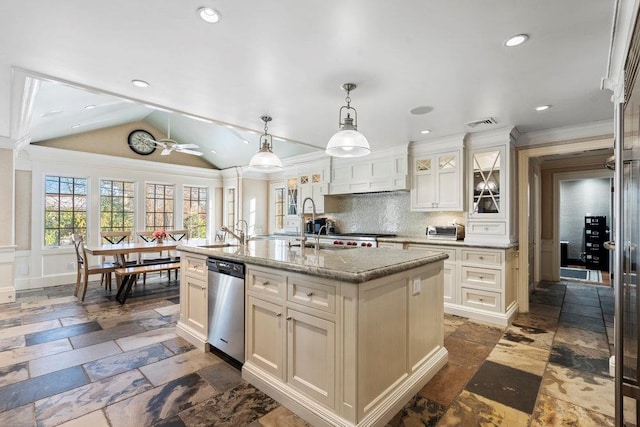 kitchen with stainless steel dishwasher, pendant lighting, vaulted ceiling, decorative backsplash, and a center island with sink