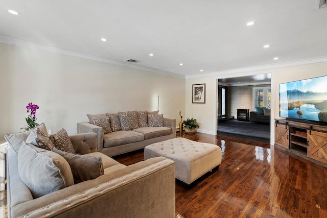 living room featuring a large fireplace, dark hardwood / wood-style flooring, and crown molding