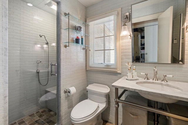 bathroom featuring tile walls, vanity, an enclosed shower, and toilet