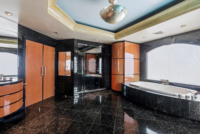 bathroom featuring a raised ceiling, sink, and plus walk in shower