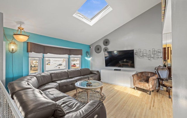 living area featuring high vaulted ceiling, a skylight, and wood finished floors