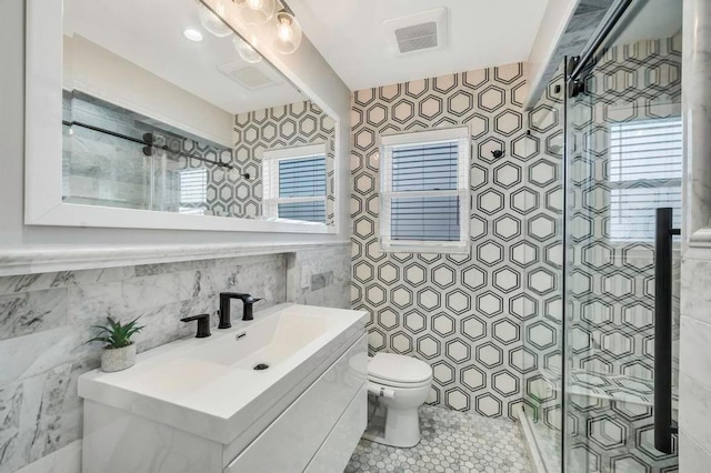 bathroom featuring vanity, toilet, and a shower with door