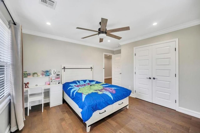 bedroom featuring dark hardwood / wood-style flooring, a closet, ceiling fan, and crown molding