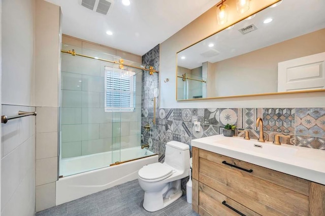 full bathroom with vanity, backsplash, tile patterned floors, bath / shower combo with glass door, and toilet