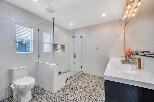 bathroom featuring tile patterned flooring, vanity, a shower with shower door, and toilet