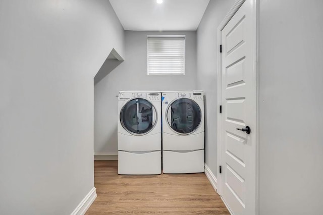 laundry area featuring washer and dryer and light hardwood / wood-style floors