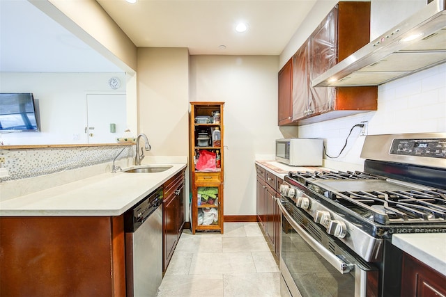 kitchen featuring sink, wall chimney exhaust hood, stainless steel appliances, decorative backsplash, and light tile patterned flooring