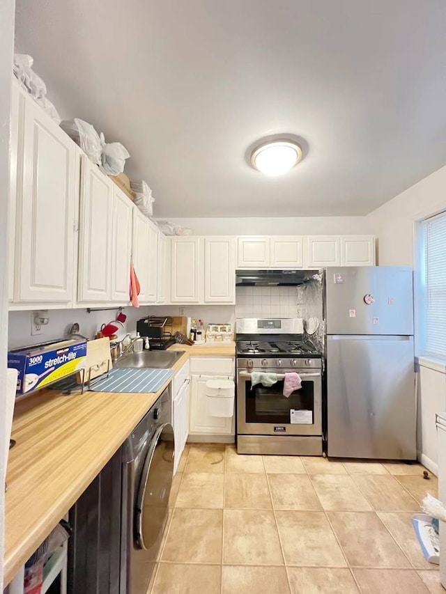 kitchen featuring washer / dryer, white cabinetry, sink, and appliances with stainless steel finishes