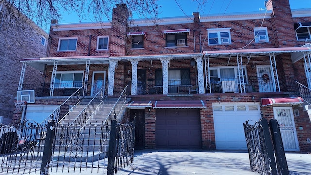 multi unit property featuring stairway, fence, driveway, brick siding, and a garage
